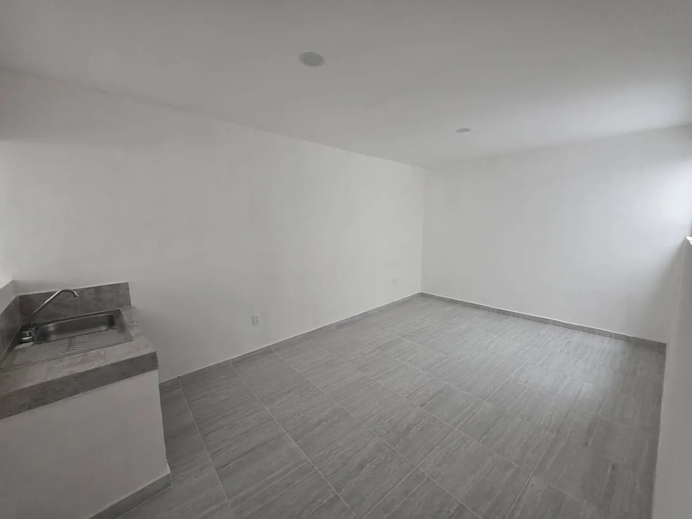 La sala con cocineta, vacía